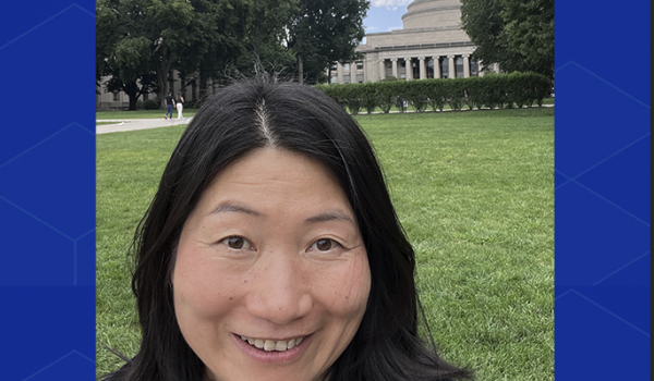 Huilin Tu, standing in front of the MIT dome. Only her head is visible, and she's smiling.